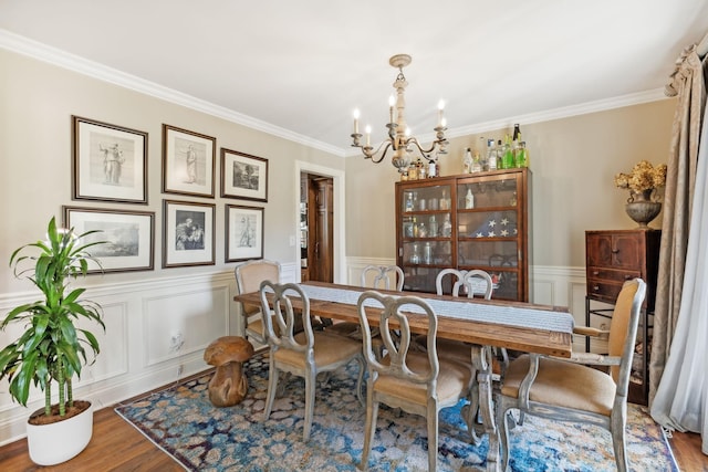 dining room with a chandelier, hardwood / wood-style floors, and crown molding