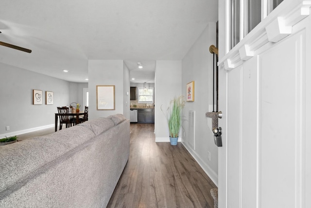 living room with ceiling fan and dark wood-type flooring