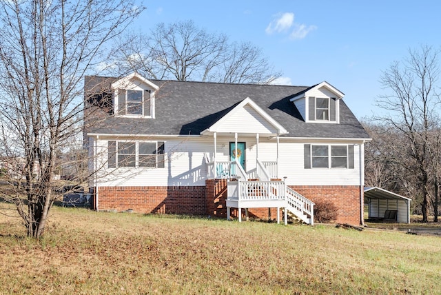 cape cod-style house with a front lawn, covered porch, and a carport