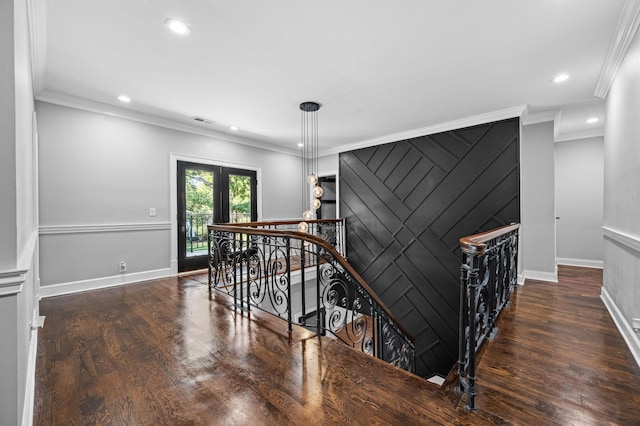 stairway with wood-type flooring and ornamental molding