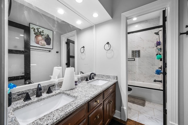 full bathroom featuring vanity, enclosed tub / shower combo, and toilet