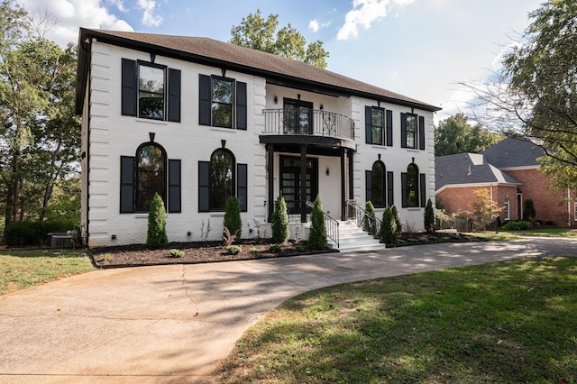 view of front of home featuring a front yard and a balcony