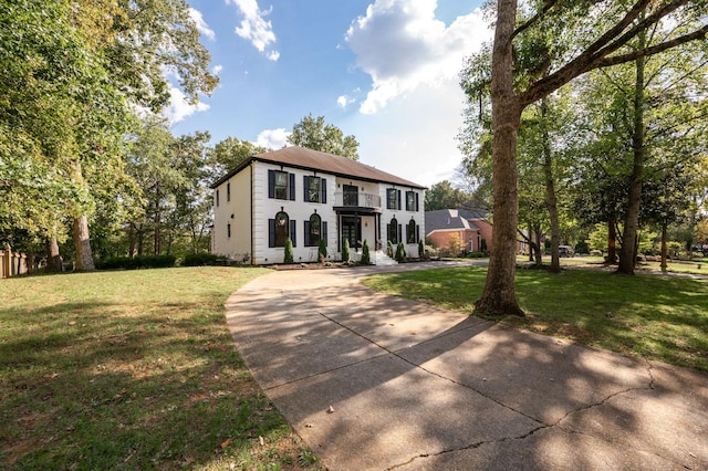 colonial-style house featuring a front lawn