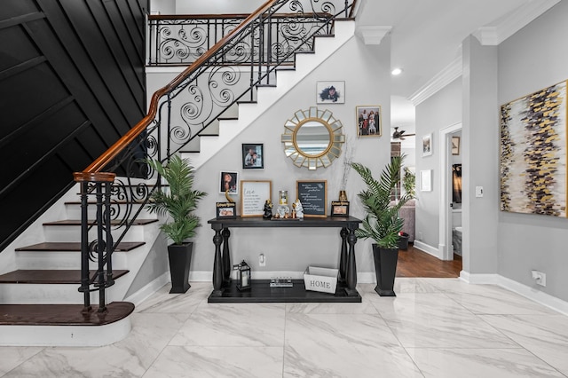 foyer entrance with ornamental molding and a high ceiling