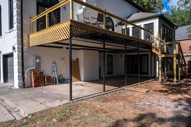 back of property featuring a garage and a wooden deck