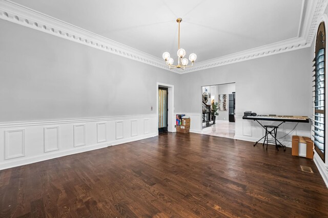 unfurnished room with a notable chandelier, dark hardwood / wood-style flooring, and ornamental molding