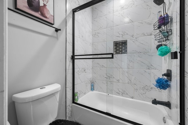 bathroom with toilet and bath / shower combo with glass door