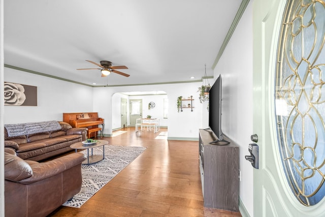 living room featuring crown molding, ceiling fan, and wood-type flooring