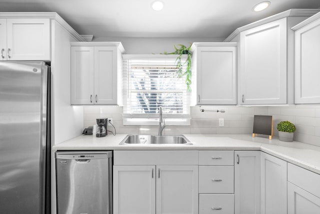 kitchen with tasteful backsplash, white cabinetry, sink, and stainless steel appliances