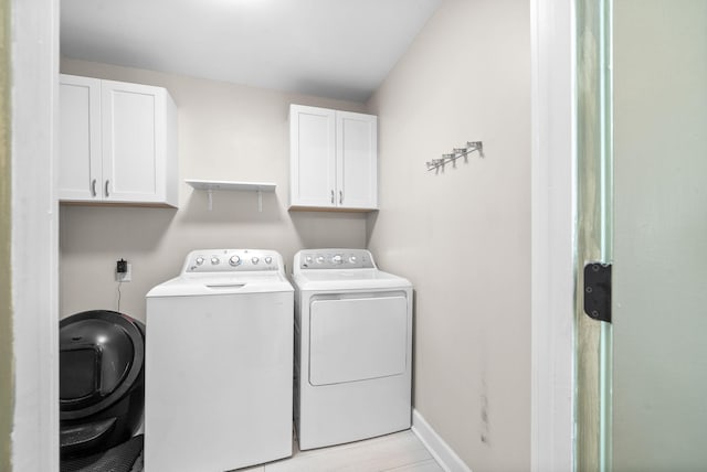 laundry room with washer and clothes dryer and cabinets