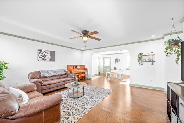 living room featuring ceiling fan, light hardwood / wood-style flooring, and ornamental molding