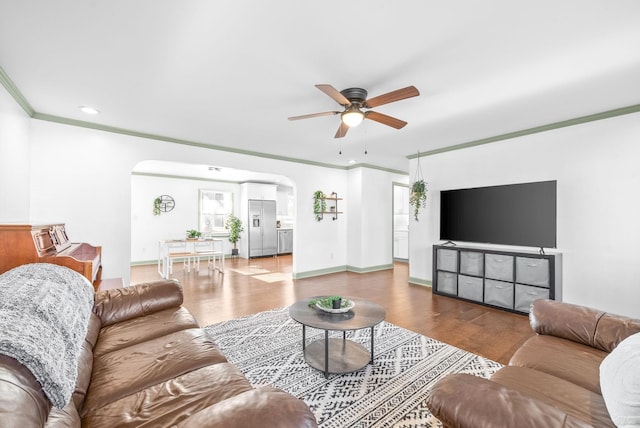 living room with wood-type flooring, ceiling fan, and crown molding