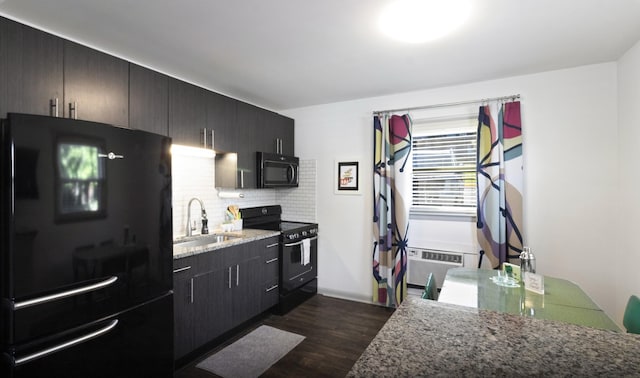 kitchen featuring black appliances, sink, decorative backsplash, light stone countertops, and dark hardwood / wood-style flooring