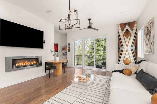 living room featuring hardwood / wood-style floors and ceiling fan with notable chandelier