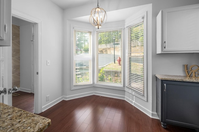 dining area featuring dark hardwood / wood-style floors, a wealth of natural light, and a chandelier