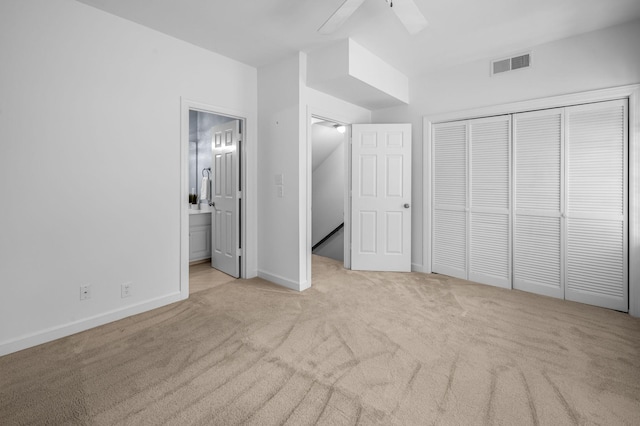 unfurnished bedroom featuring connected bathroom, ceiling fan, a closet, and light carpet