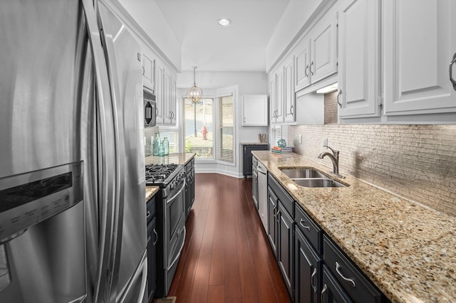 kitchen with pendant lighting, dark wood-type flooring, white cabinets, sink, and appliances with stainless steel finishes