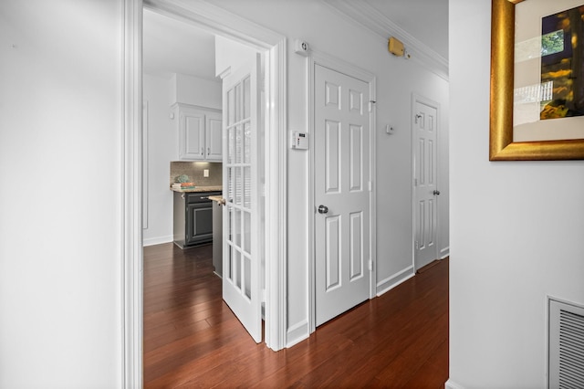 hall with ornamental molding and dark wood-type flooring