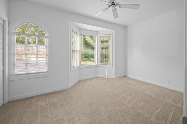 empty room featuring light carpet and ceiling fan