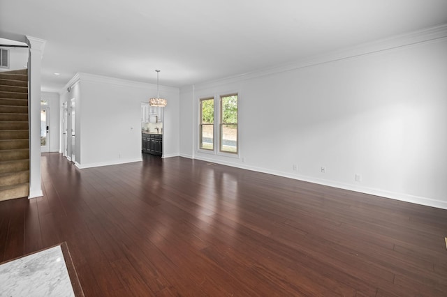 unfurnished living room featuring dark hardwood / wood-style floors, crown molding, and a chandelier