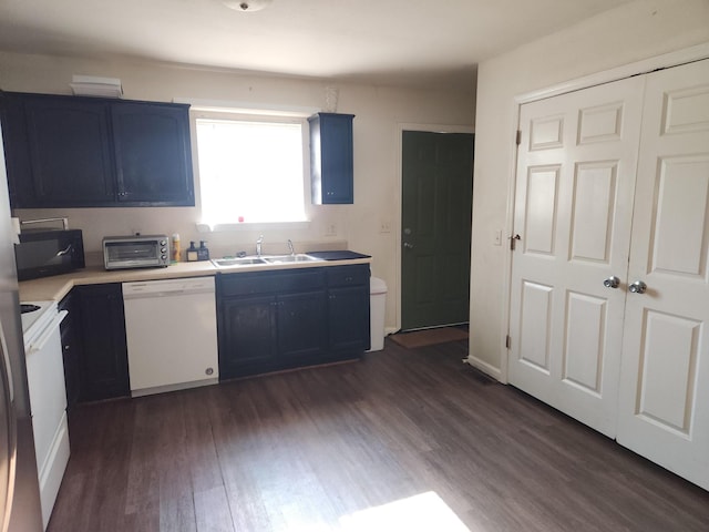 kitchen featuring white appliances, dark hardwood / wood-style floors, blue cabinets, and sink