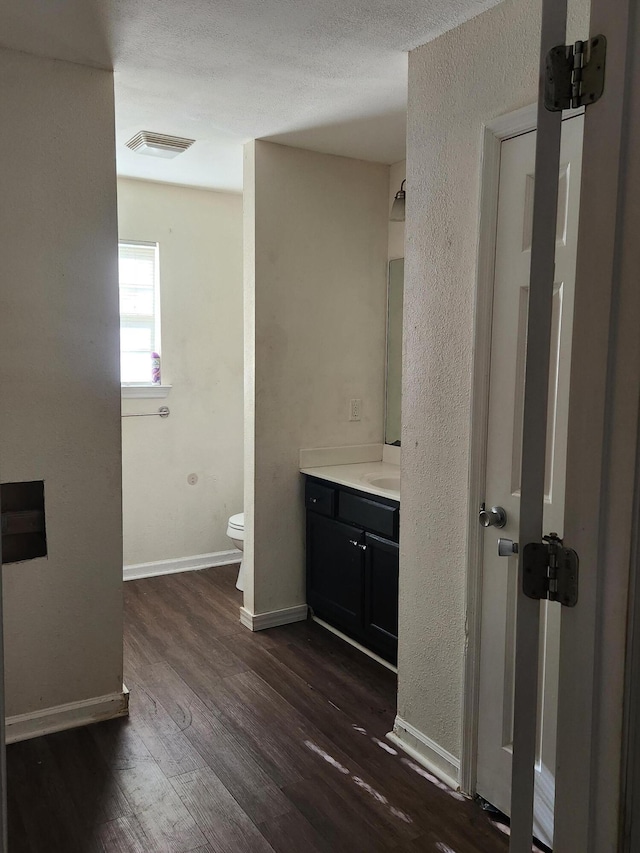 bathroom with wood-type flooring, vanity, and toilet