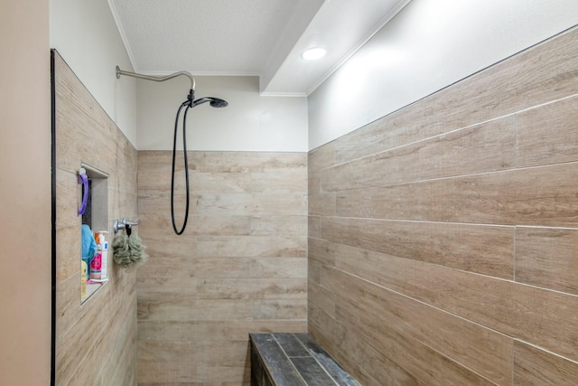 bathroom with ornamental molding, a textured ceiling, and tiled shower