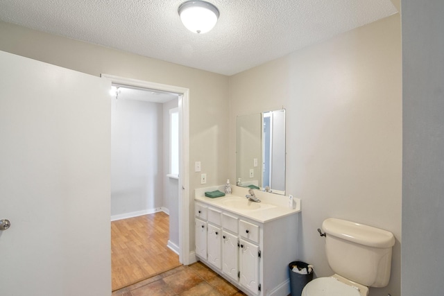 bathroom with tile patterned floors, vanity, toilet, and a textured ceiling