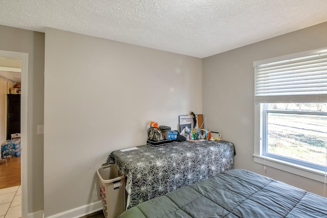 bedroom with light tile patterned floors and a textured ceiling