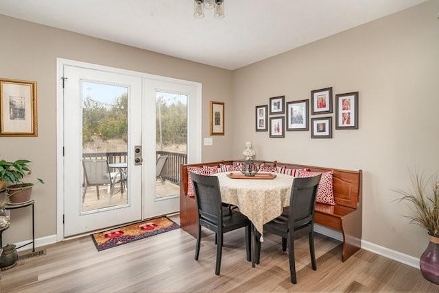 dining area with light hardwood / wood-style flooring and french doors