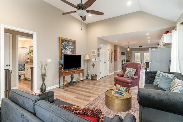 living room with light hardwood / wood-style flooring, high vaulted ceiling, french doors, and ceiling fan