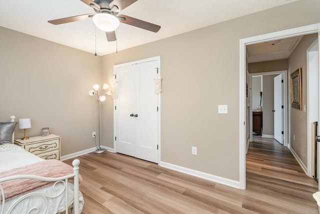 bedroom with ceiling fan, light hardwood / wood-style floors, and a closet