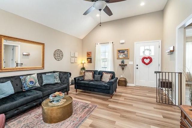 living room with vaulted ceiling, ceiling fan, and light hardwood / wood-style flooring