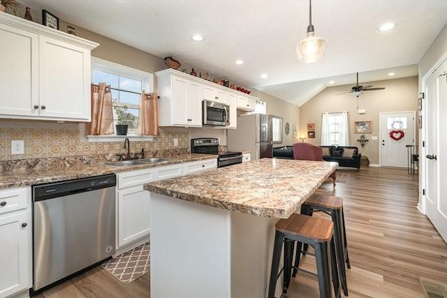 kitchen featuring white cabinetry, appliances with stainless steel finishes, sink, and pendant lighting