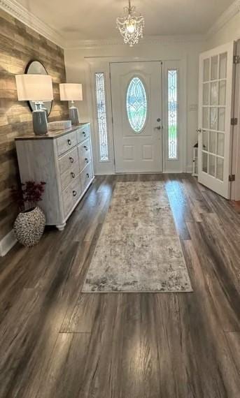 foyer entrance with dark wood-type flooring and an inviting chandelier