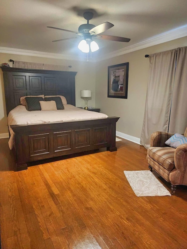 bedroom with hardwood / wood-style floors, ceiling fan, and ornamental molding