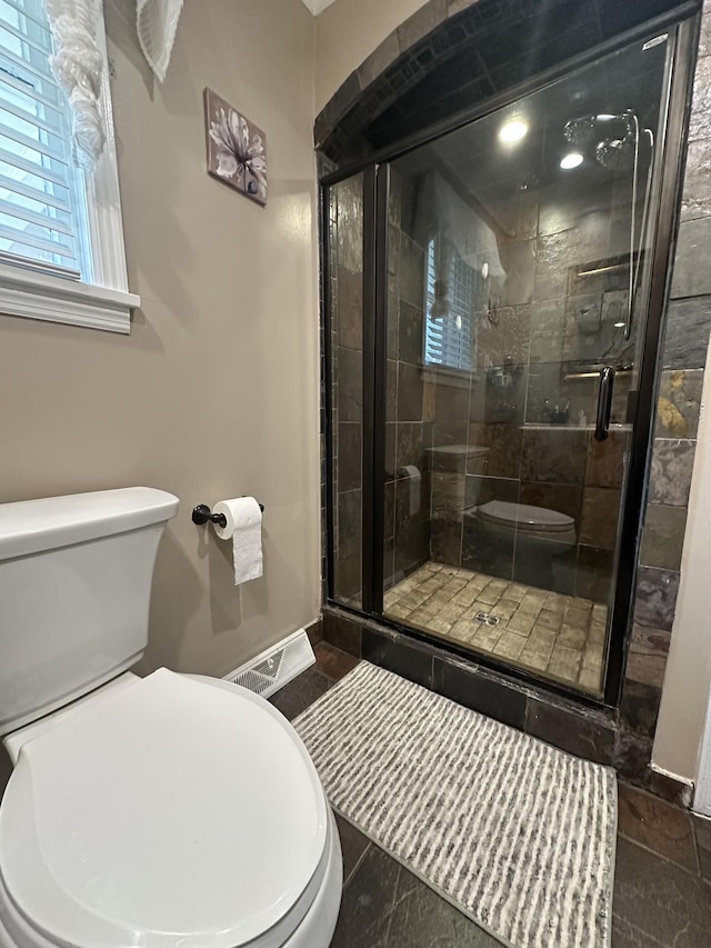 bathroom with an enclosed shower and toilet