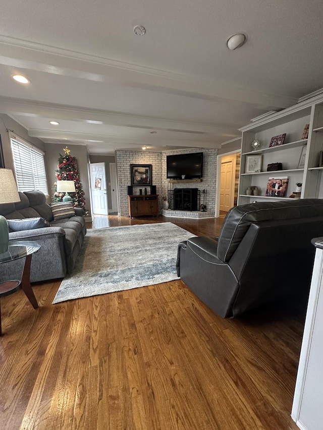 living room featuring hardwood / wood-style flooring, beam ceiling, and a fireplace