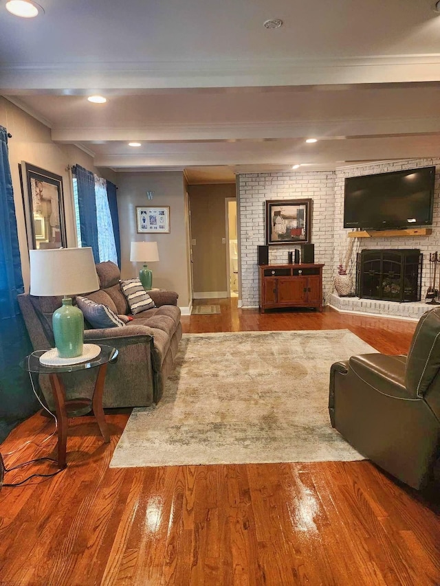 living room with beam ceiling, a brick fireplace, and hardwood / wood-style floors