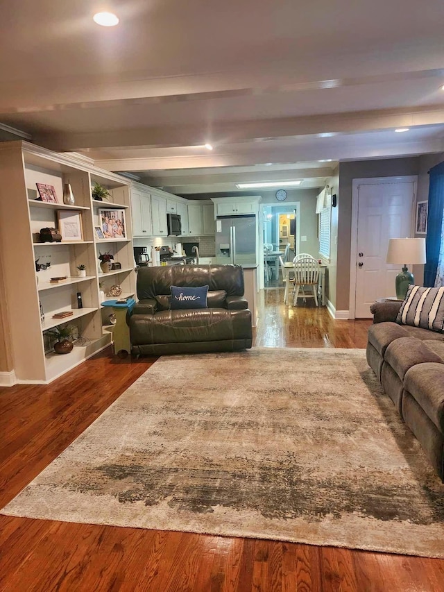 living room featuring beamed ceiling and hardwood / wood-style flooring