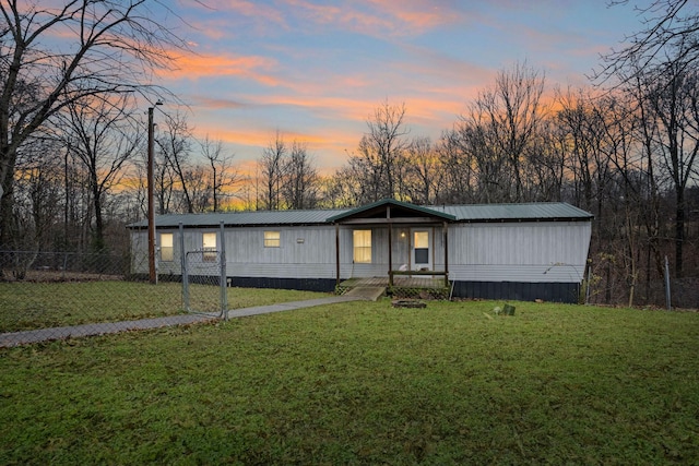 manufactured / mobile home featuring covered porch and a yard