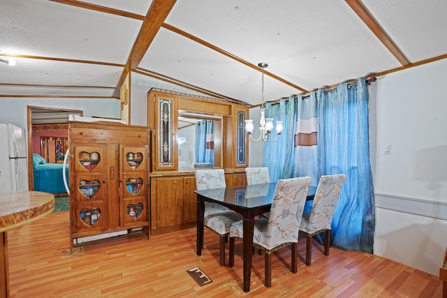 dining room featuring an inviting chandelier, lofted ceiling, and light wood-type flooring