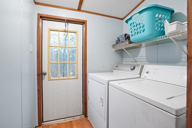 laundry room featuring crown molding, light hardwood / wood-style floors, and independent washer and dryer