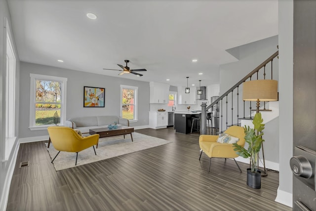 living room with ceiling fan, dark wood-type flooring, and sink