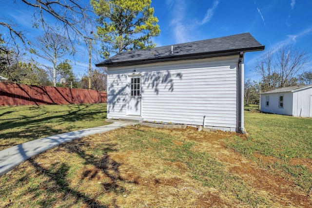 rear view of property featuring an outdoor structure and a yard