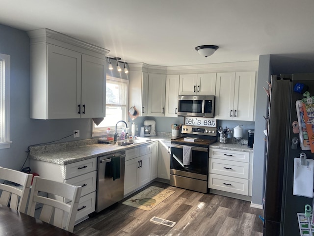 kitchen featuring dark hardwood / wood-style flooring, sink, white cabinets, and appliances with stainless steel finishes