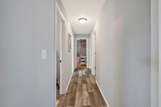 corridor featuring wood finished floors and baseboards