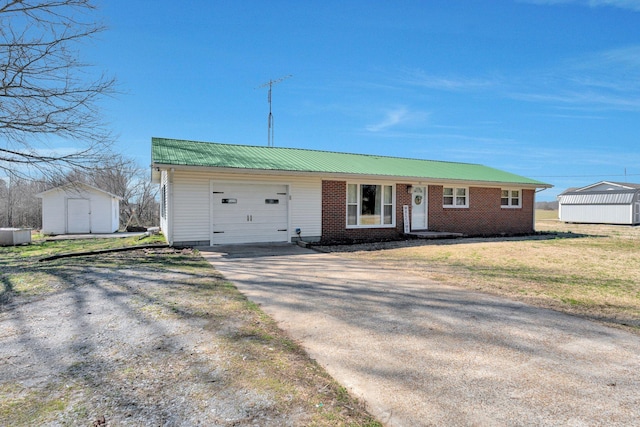 ranch-style house featuring a storage shed, concrete driveway, an outbuilding, an attached garage, and brick siding