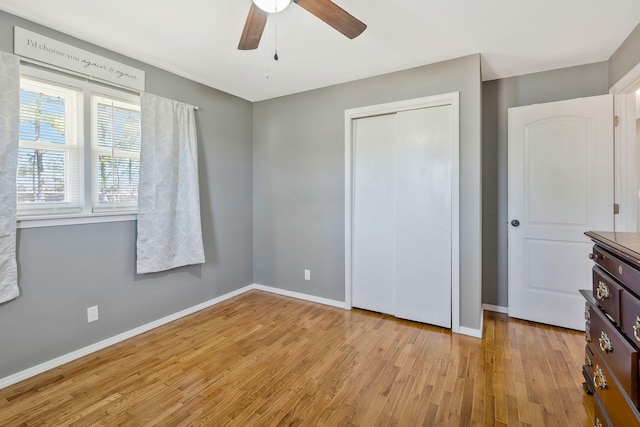 unfurnished bedroom with light wood-type flooring, ceiling fan, baseboards, and a closet