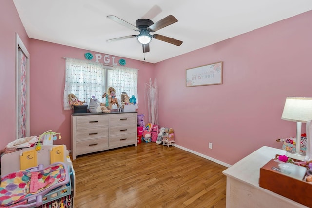 bedroom with ceiling fan, wood finished floors, and baseboards